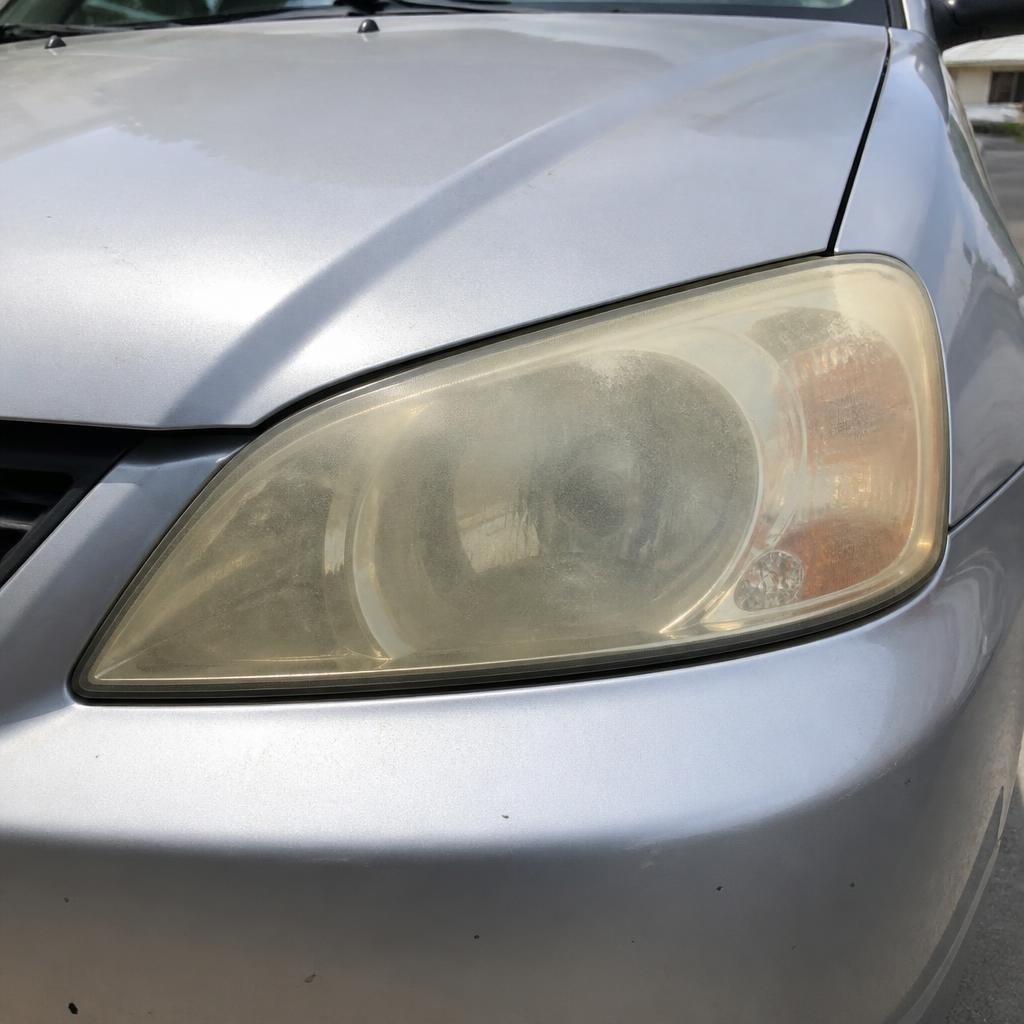 Headlight restoration on a silver Honda Civic — before restoration