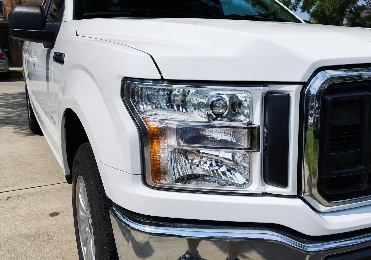 Headlight restoration on a white Ford F-150 truck — after restoration